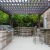 a covered patio with a grill tables and chairs